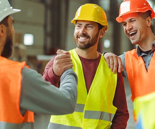 Two construction professionals on site reviewing information on a tablet.