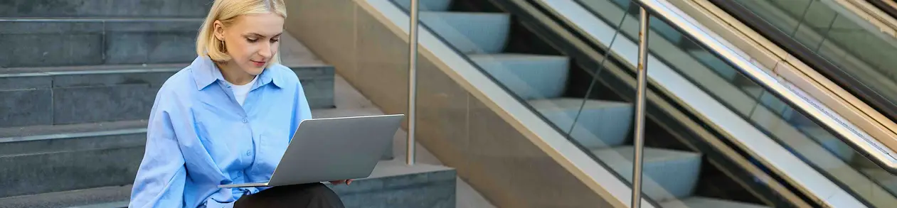 Technology professionals smiling while working on a laptop.